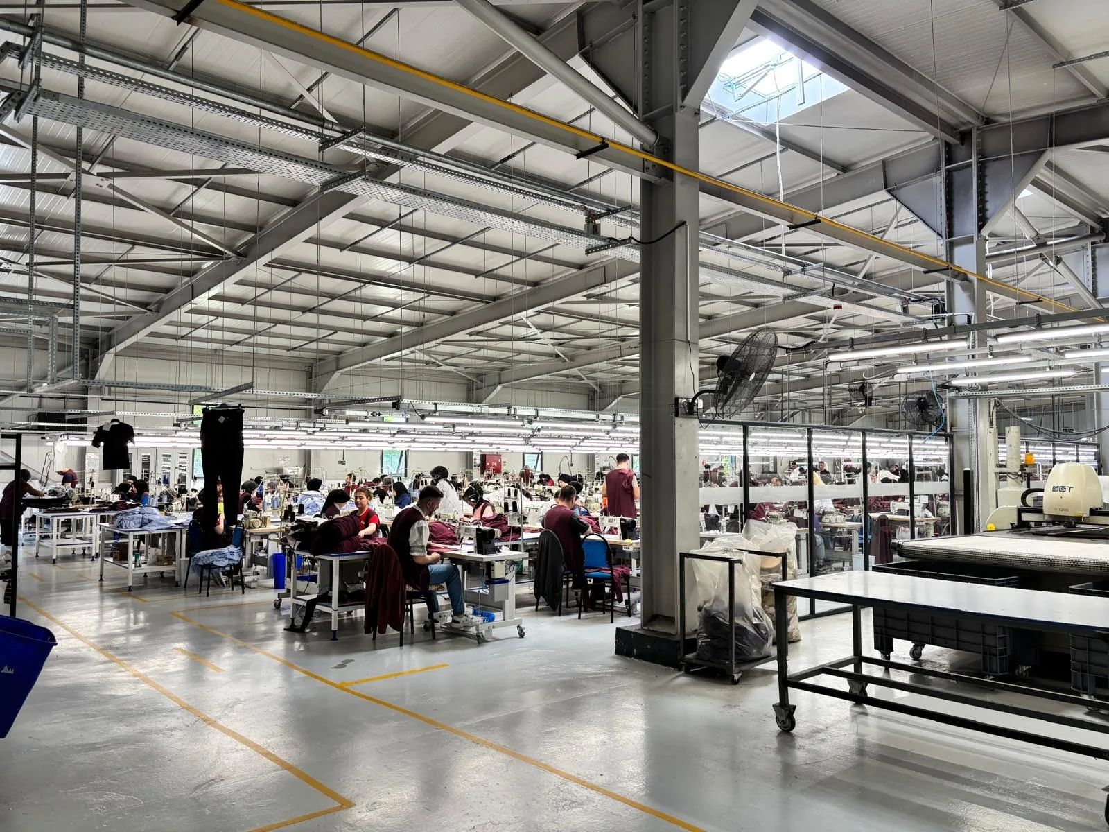 Çatı pencereleri ve uzun LED aydınlatmalarla çelik çatılı Erbaa üretim salonu