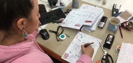 Masasında teknik föy üzerinde işaretleme yapan bir modelist