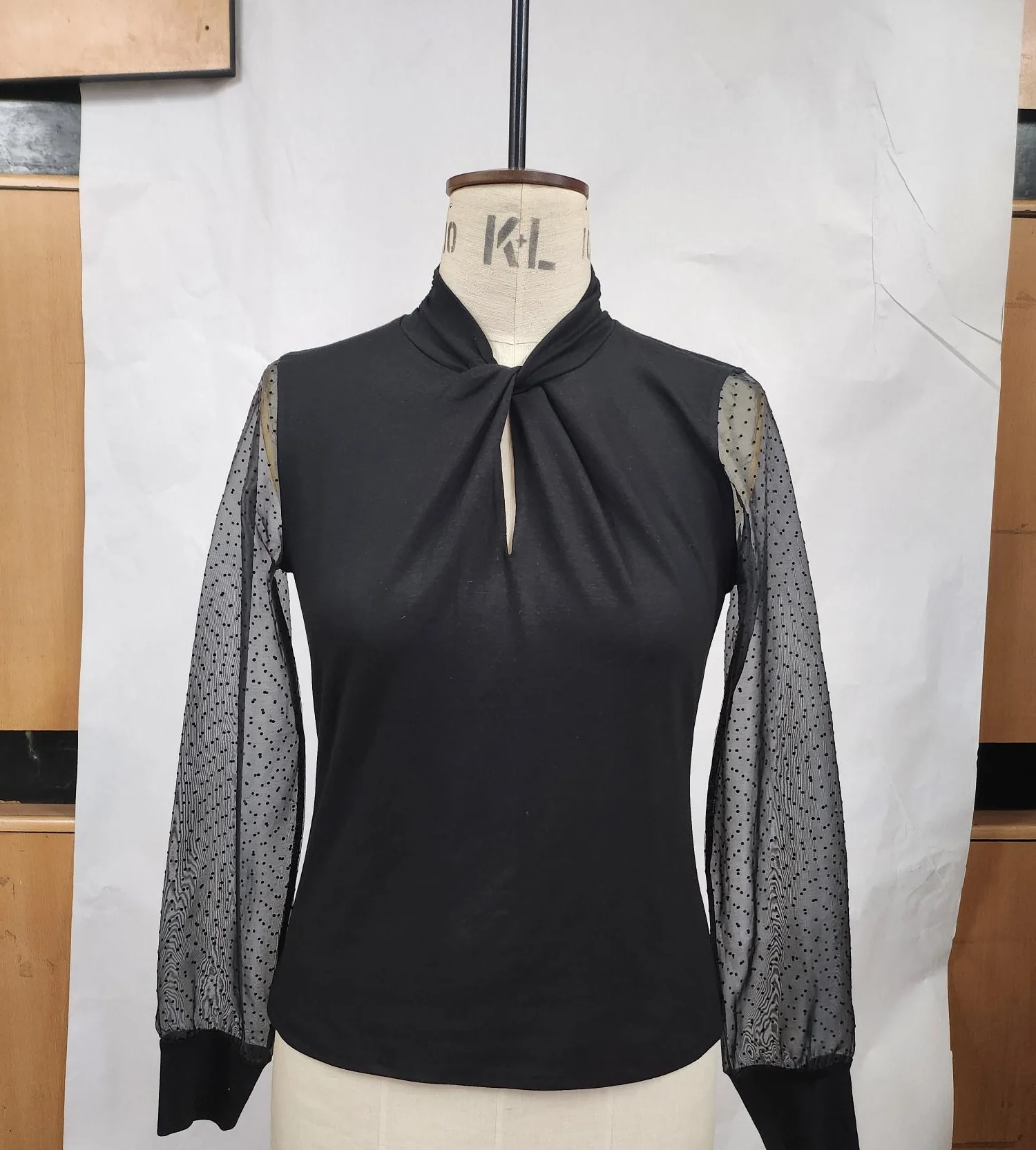 Prova mankeni üzerinde şeffaf puantiyeli kollu siyah örme bluz numunesi, Karl Lagerfeld için üretildi