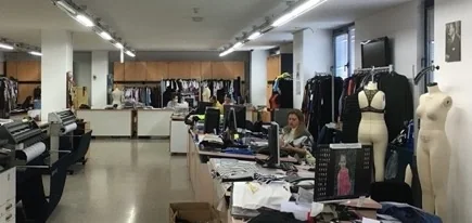 Darsateks ürün geliştirme stüdyosu: masalar, bir çizici ve numune giydirilmiş prova mankenleri